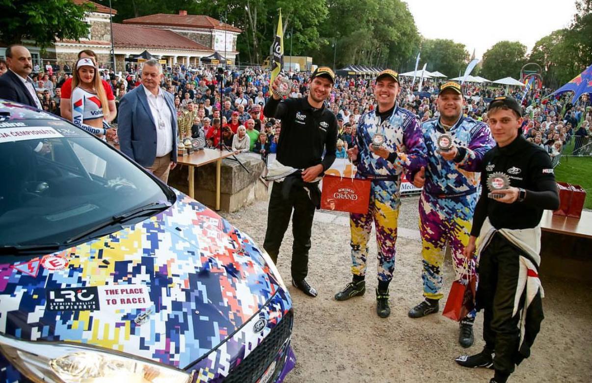 Danila on a rally podium with a trophy